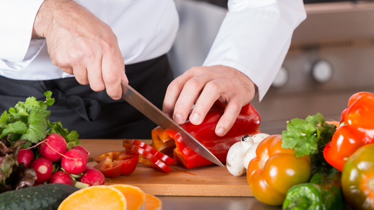 [alt=料理のプロが野菜を切っている様子。]

