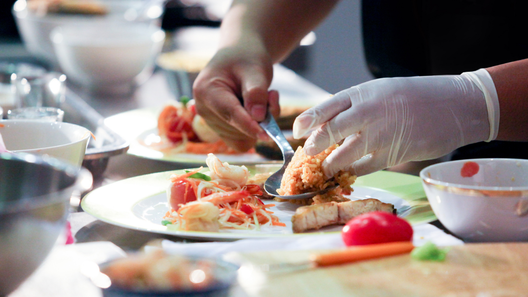 [alt=調理師を目指す学生が実習で調理をしているイメージ。]