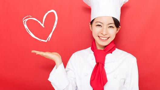 [alt=赤い背景にハートマーク。笑顔のパティシエの姿。]

