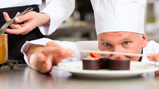 [alt=パティシエがチョコレートケーキを作っている様子。]

