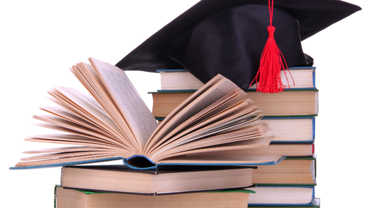 [alt=積み上げられた本とアカデミー帽の画像。]
